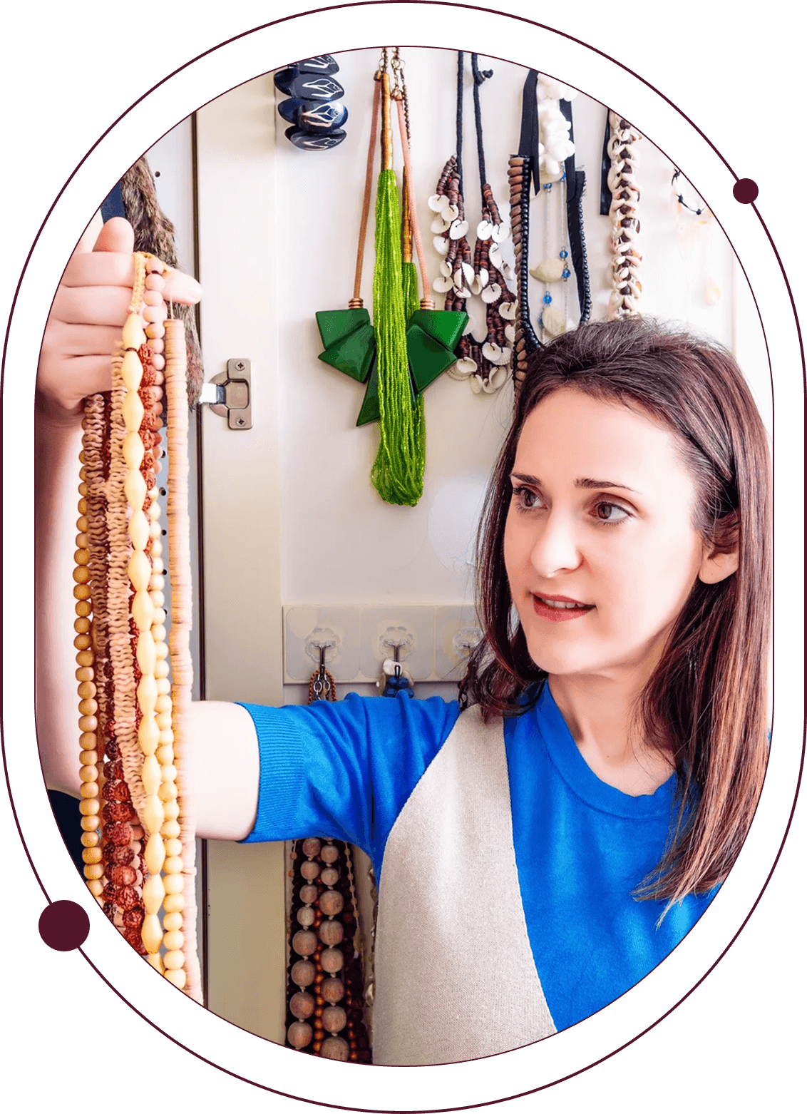 Woman examining colorful beaded necklaces hanging.