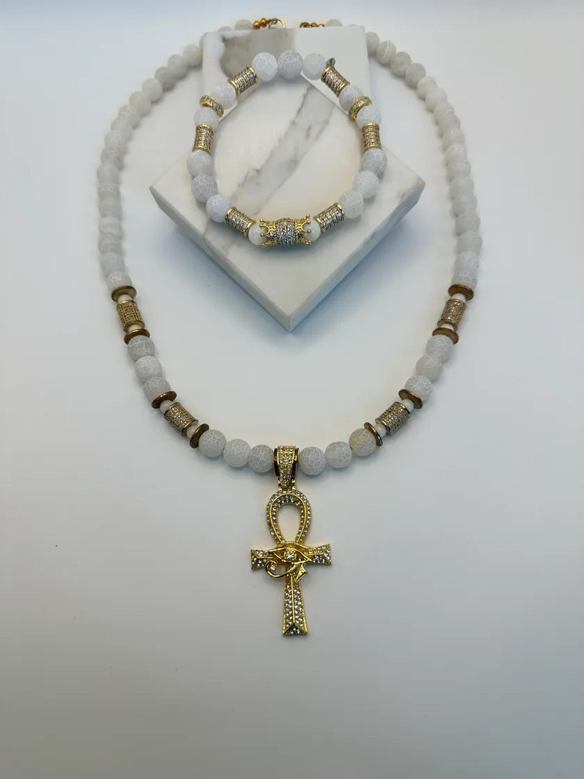 White beaded necklace with gold ankh pendant.