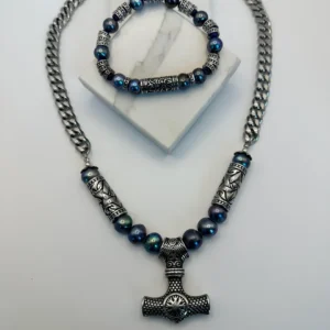 A stylish Thor's hammer pendant necklace with matching bracelet on display.
