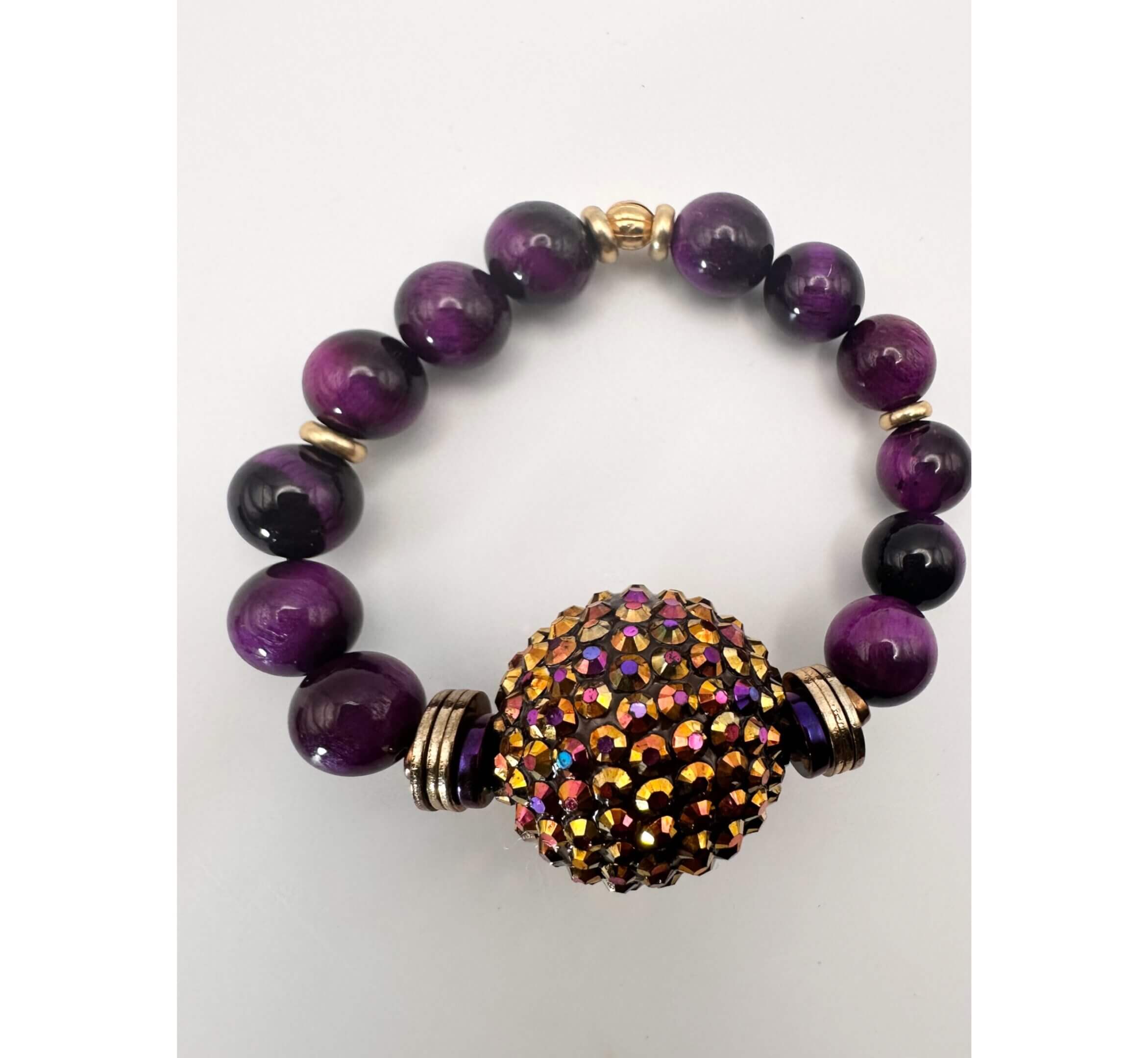 Purple beaded bracelet with a multicolored centerpiece bead.