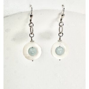 Elegant handmade earrings with blue stones and white circular bases.